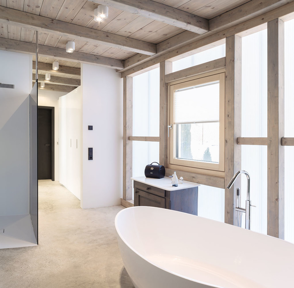 Свежая идея для дизайна: главная ванная комната среднего размера в стиле модернизм с плоскими фасадами, белыми фасадами, отдельно стоящей ванной, душем без бортиков, инсталляцией, бетонным полом, настольной раковиной, серым полом, открытым душем и белыми стенами - отличное фото интерьера