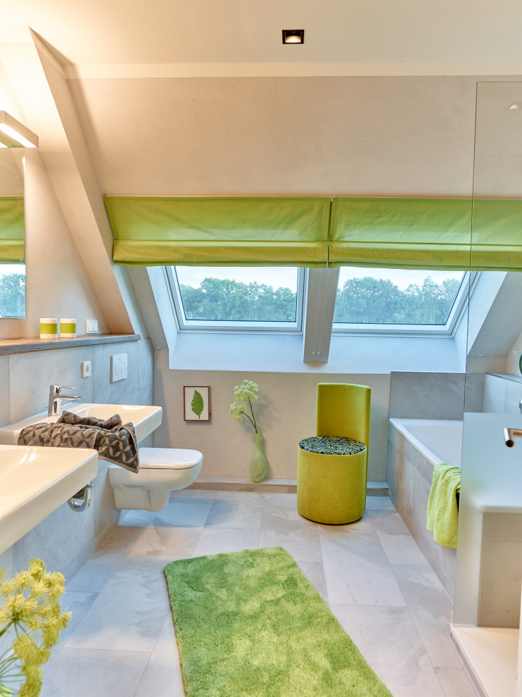 ハンブルクにある広いコンテンポラリースタイルのおしゃれなマスターバスルーム (ドロップイン型浴槽、壁掛け式トイレ、グレーのタイル、ベージュの壁、磁器タイルの床、壁付け型シンク、グレーの床、オープンシャワー) の写真