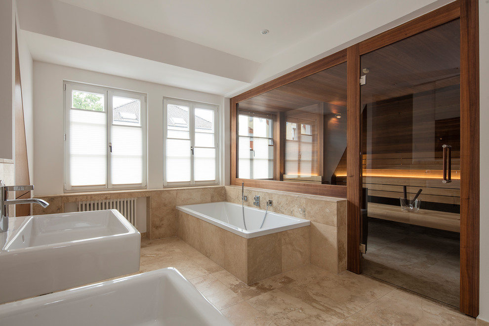 Foto på ett stort funkis en-suite badrum, med ett platsbyggt badkar, beige kakel, vita väggar, ett väggmonterat handfat och beiget golv