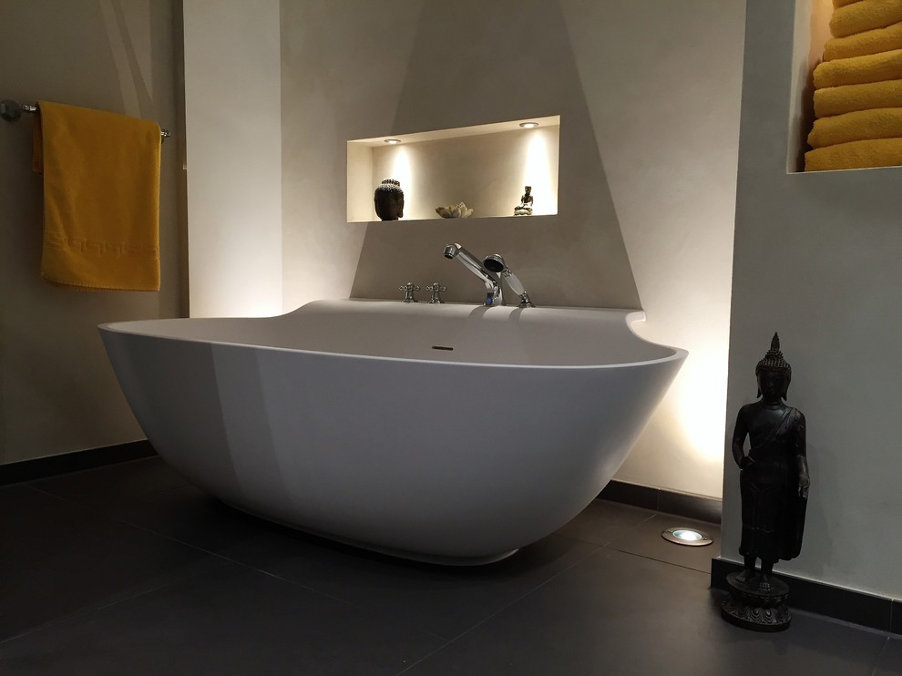 Foto di una stanza da bagno con doccia etnica di medie dimensioni con vasca freestanding, vasca/doccia, pareti beige, pavimento in cementine e pavimento nero
