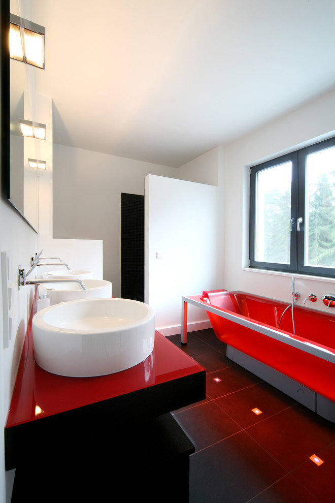Ispirazione per una stanza da bagno minimal di medie dimensioni con vasca freestanding, pareti bianche, lavabo a bacinella e top in vetro