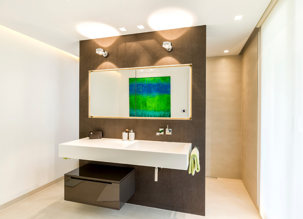 Modern inredning av ett badrum, med släta luckor, vita väggar, ett integrerad handfat och med dusch som är öppen