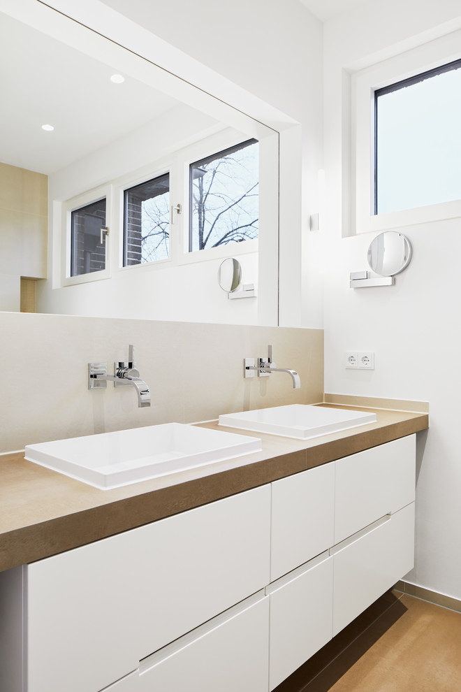 Foto de cuarto de baño contemporáneo con armarios con paneles lisos, puertas de armario blancas, baldosas y/o azulejos beige, lavabo sobreencimera y encimeras marrones