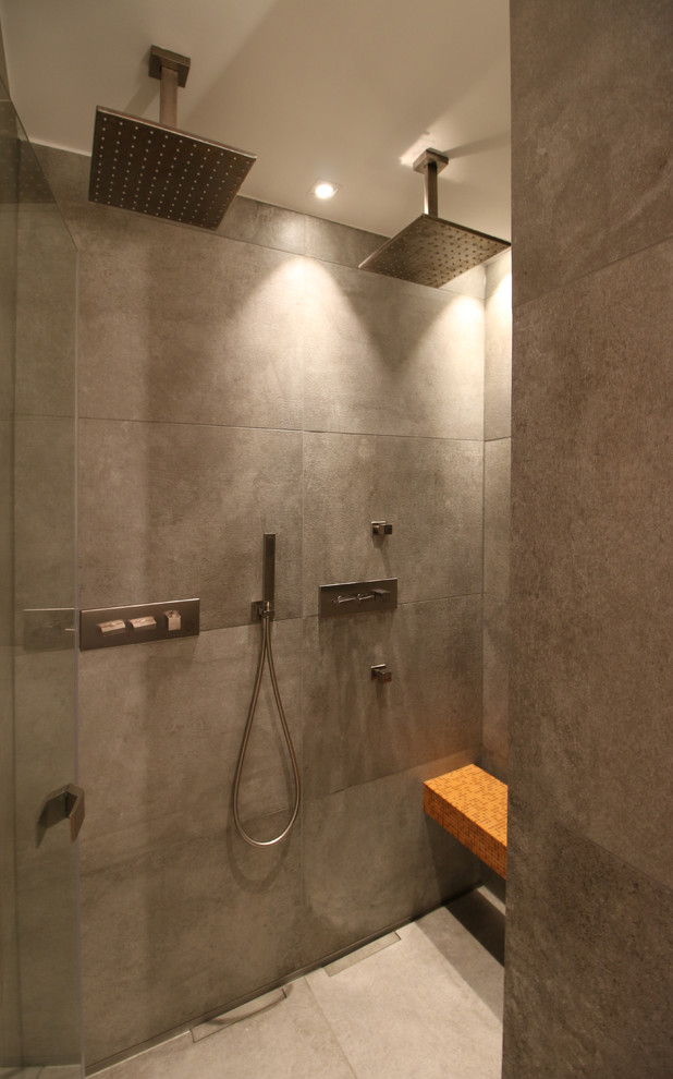 Exempel på ett stort industriellt grå grått badrum med dusch, med skåp i mörkt trä, en kantlös dusch, en vägghängd toalettstol, grå kakel, perrakottakakel, vita väggar, klinkergolv i keramik, ett integrerad handfat, kaklad bänkskiva och grått golv