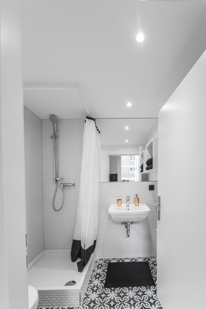 Ejemplo de cuarto de baño tradicional pequeño con lavabo suspendido, ducha esquinera, baldosas y/o azulejos blancas y negros, paredes blancas, aseo y ducha, baldosas y/o azulejos de cemento y suelo de baldosas de cerámica