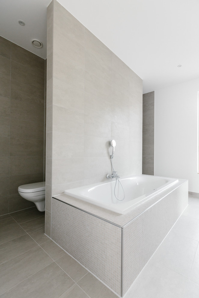 Exemple d'une salle de bain moderne avec une baignoire posée, un mur blanc, un sol en carrelage de céramique et un sol beige.