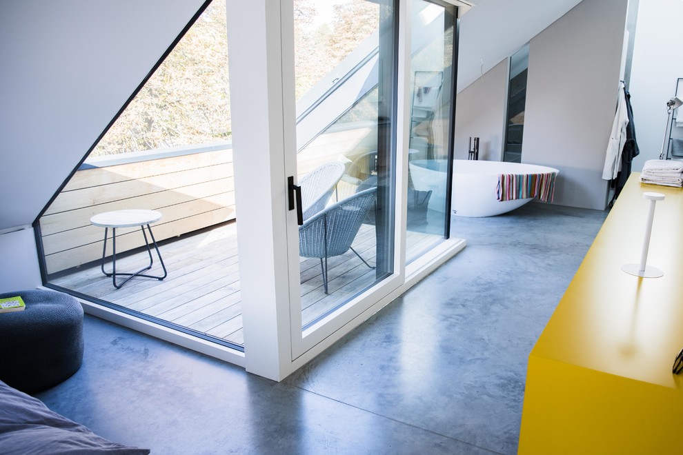 Immagine di una stanza da bagno padronale moderna di medie dimensioni con pavimento in cemento, vasca freestanding, pareti grigie, pavimento grigio e top giallo