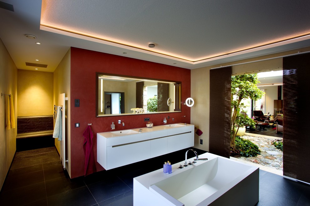 Immagine di una stanza da bagno contemporanea con vasca freestanding, doccia aperta e pareti gialle
