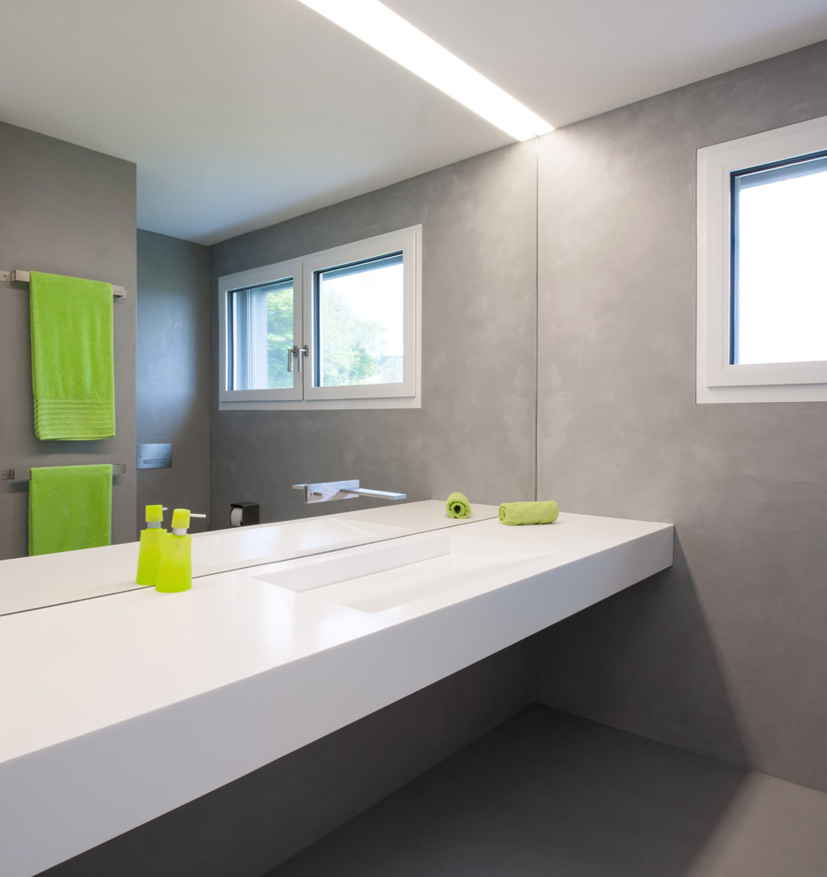 Imagen de cuarto de baño moderno con puertas de armario blancas, lavabo integrado y encimera de acrílico