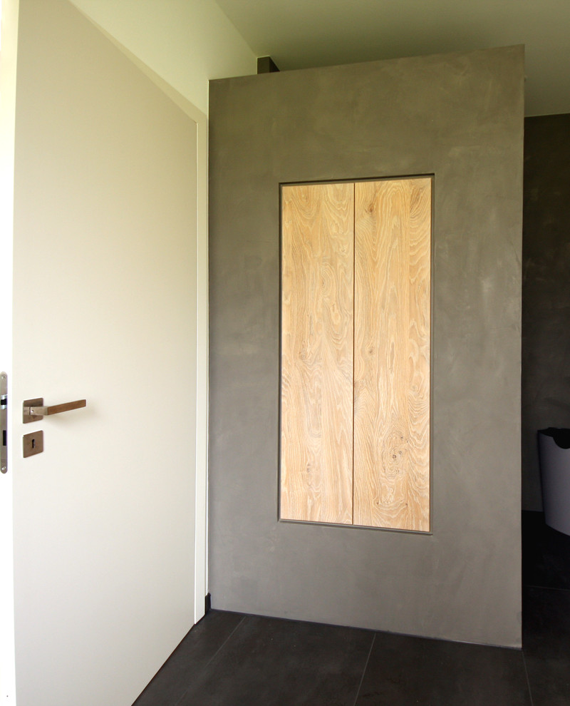 Foto di una piccola stanza da bagno con doccia minimal con ante in legno chiaro, pavimento nero, doccia aperta e ante lisce