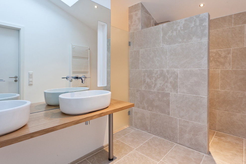 Ispirazione per una grande stanza da bagno con doccia minimal con piastrelle beige, pareti bianche, lavabo a bacinella e top in legno