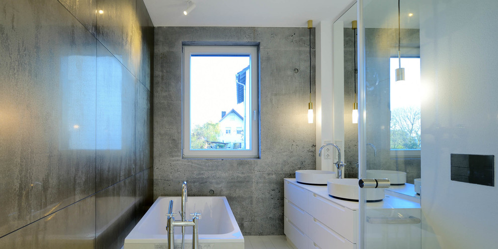 Источник вдохновения для домашнего уюта: ванная комната среднего размера в современном стиле с плоскими фасадами, белыми фасадами, накладной ванной, серой плиткой, каменной плиткой, серыми стенами, настольной раковиной и столешницей из дерева