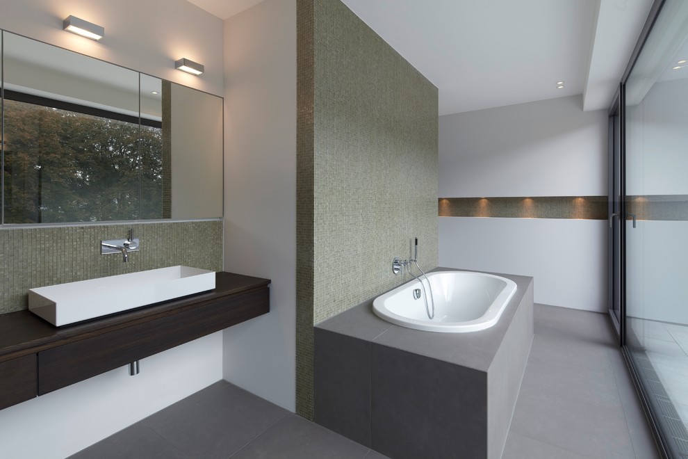 Ejemplo de cuarto de baño principal actual grande con bañera encastrada, baldosas y/o azulejos verdes, baldosas y/o azulejos en mosaico, paredes blancas y lavabo sobreencimera