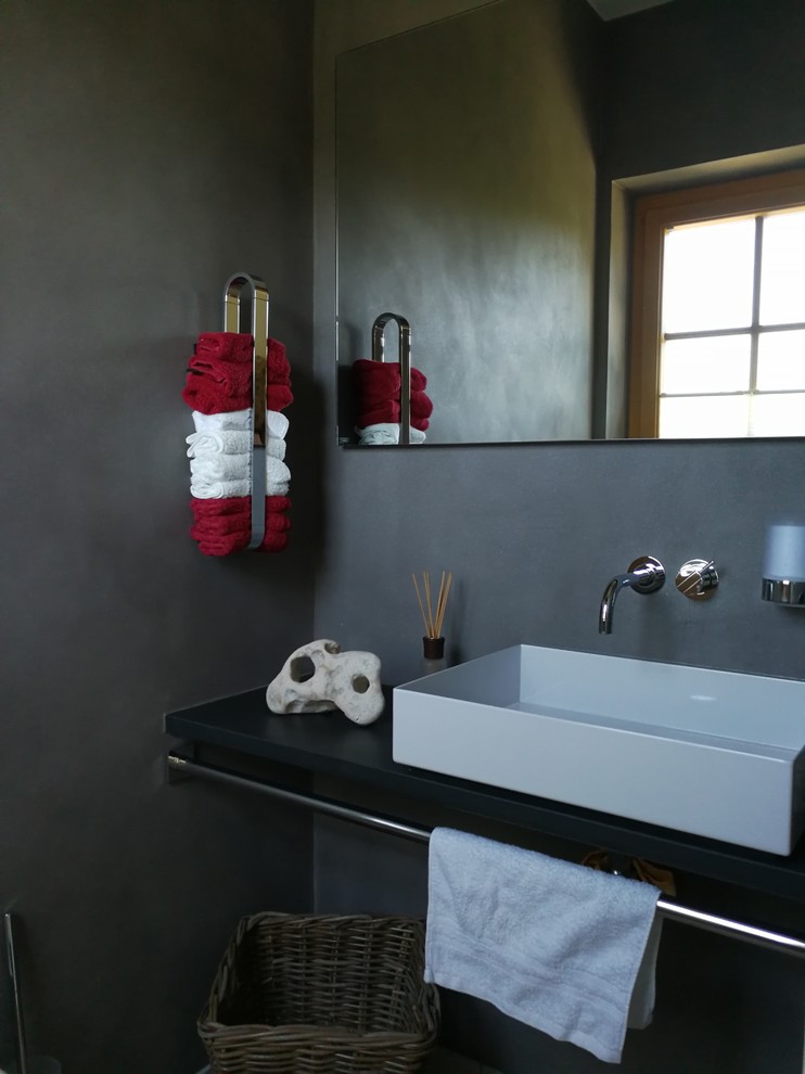 Foto på ett mellanstort funkis en-suite badrum, med släta luckor, beige skåp, ett hörnbadkar, en kantlös dusch, en vägghängd toalettstol, stenhäll, grå väggar, kalkstensgolv, ett fristående handfat, granitbänkskiva, beiget golv och dusch med skjutdörr