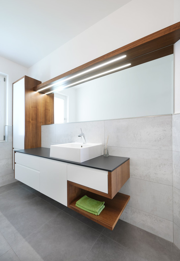На фото: ванная комната среднего размера в современном стиле с плоскими фасадами и белыми стенами с