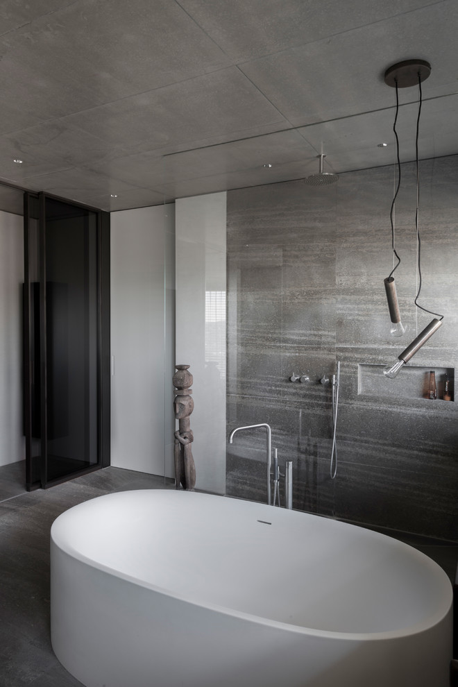 Immagine di una stanza da bagno con doccia industriale di medie dimensioni con vasca freestanding, doccia aperta, piastrelle beige, piastrelle grigie, pavimento in cemento, pavimento grigio e doccia aperta