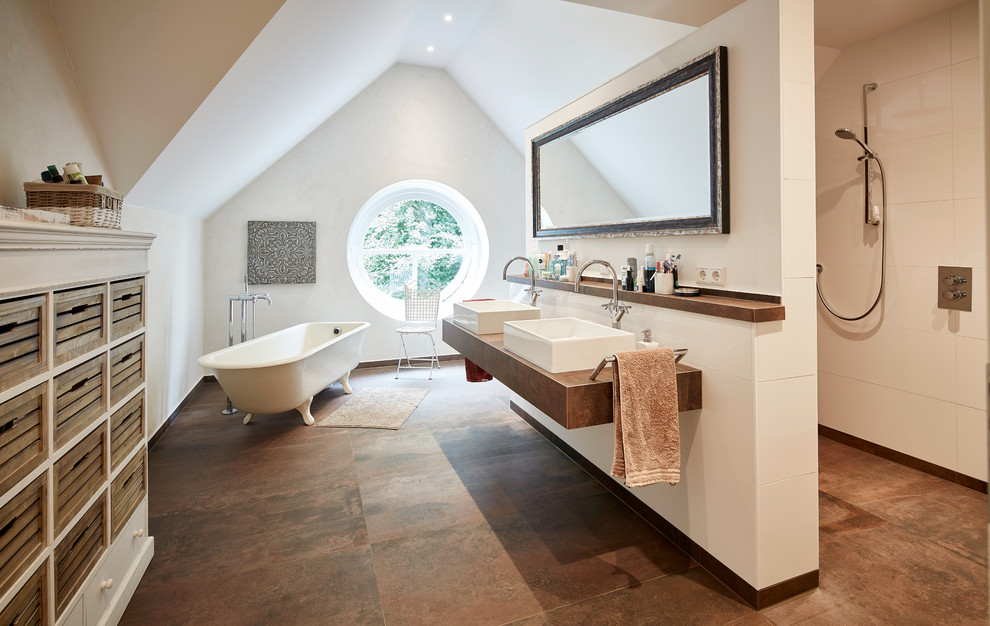 Стильный дизайн: большая главная ванная комната в стиле кантри с ванной на ножках, открытым душем, белой плиткой, белыми стенами, настольной раковиной, столешницей из дерева, коричневым полом, открытым душем, коричневой столешницей и инсталляцией - последний тренд