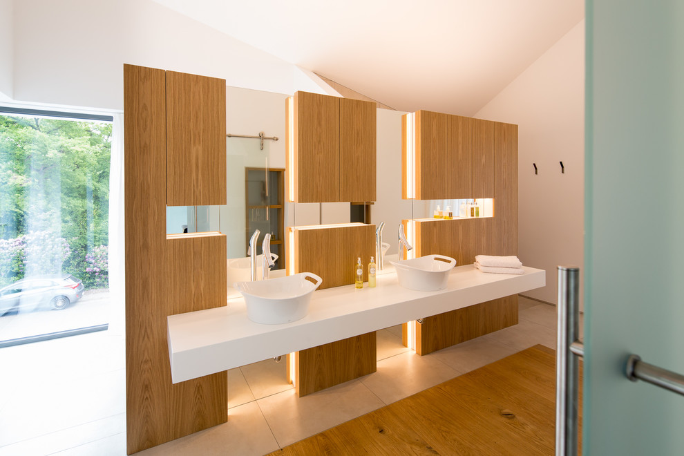 Foto de cuarto de baño principal actual grande con lavabo sobreencimera, puertas de armario de madera clara, paredes blancas, armarios con paneles lisos y ventanas