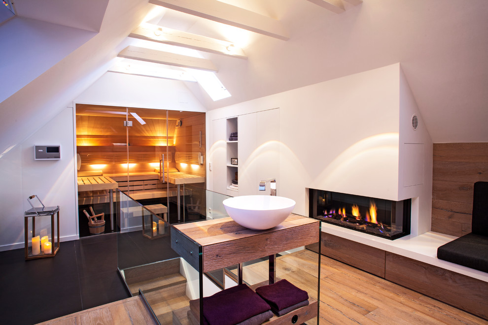 Geräumige Moderne Sauna mit Aufsatzwaschbecken, offenen Schränken, weißen Schränken, Waschtisch aus Holz, weißer Wandfarbe und braunem Holzboden in Bremen