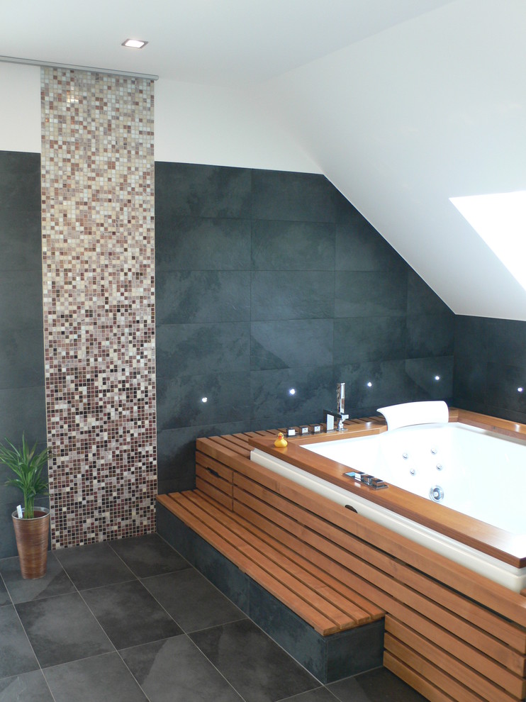 Imagen de cuarto de baño contemporáneo grande con bañera encastrada sin remate, baldosas y/o azulejos grises, losas de piedra, paredes blancas y suelo de pizarra