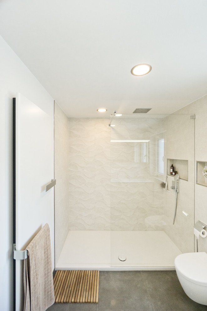Idéer för att renovera ett mellanstort funkis badrum med dusch, med en dubbeldusch, en vägghängd toalettstol, vit kakel, svarta väggar, grått golv och med dusch som är öppen