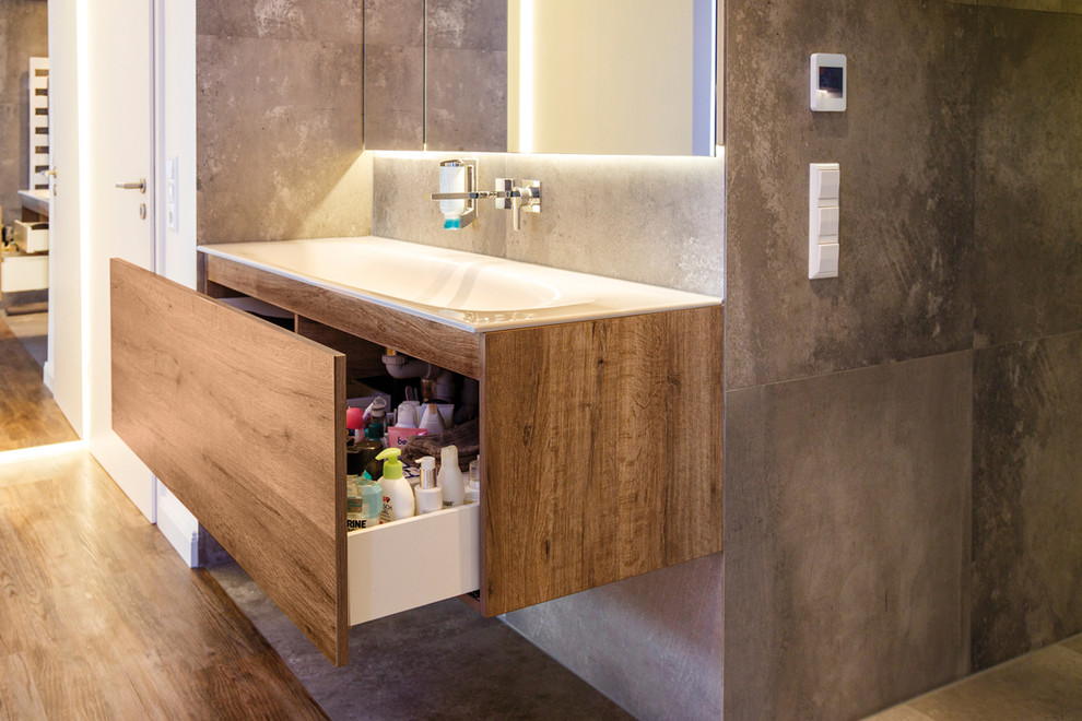 Inspiration for a medium sized contemporary ensuite bathroom in Stuttgart with flat-panel cabinets, dark wood cabinets, a built-in shower, brown tiles, ceramic tiles, white walls, ceramic flooring, a built-in sink, solid surface worktops, brown floors and an open shower.
