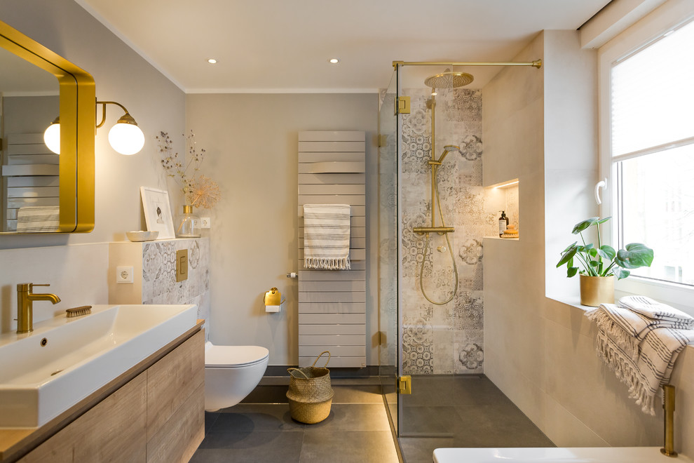 Inspiration for a contemporary bathroom in Dresden with flat-panel cabinets, medium wood cabinets, a freestanding bath, grey tiles, grey walls, a vessel sink, wooden worktops, grey floors and brown worktops.