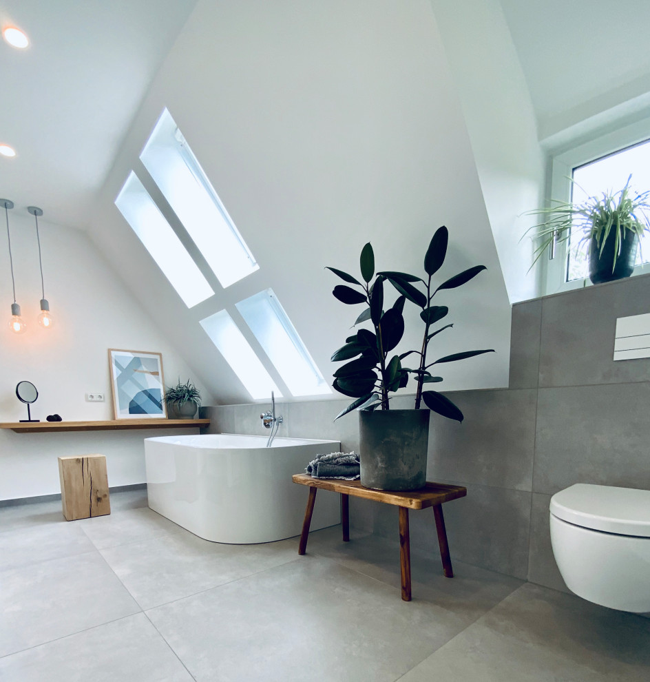 Cette photo montre une grande salle de bain tendance avec des portes de placard blanches, une baignoire indépendante, une douche ouverte, WC suspendus, un mur blanc, sol en béton ciré, une vasque, un sol gris, aucune cabine, meuble double vasque et meuble-lavabo suspendu.