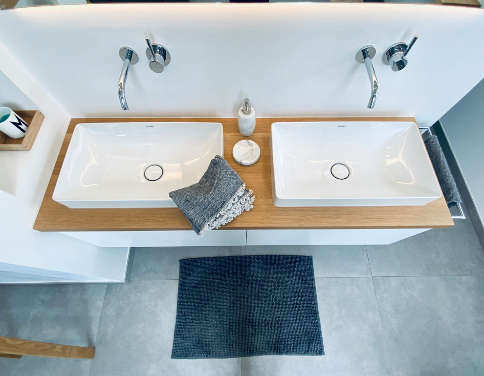 Bathroom - large contemporary concrete floor, gray floor and double-sink bathroom idea in Other with white cabinets, a wall-mount toilet, white walls, a vessel sink and a floating vanity