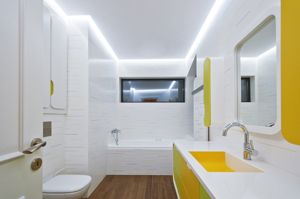 Immagine di una stanza da bagno per bambini moderna con top in superficie solida, ante lisce e pareti multicolore
