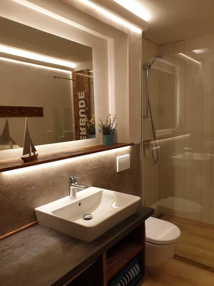 Exempel på ett litet nordiskt grå grått badrum, med bruna skåp, en kantlös dusch, en toalettstol med separat cisternkåpa, vit kakel, keramikplattor, vita väggar, klinkergolv i keramik, ett fristående handfat, träbänkskiva, brunt golv och med dusch som är öppen