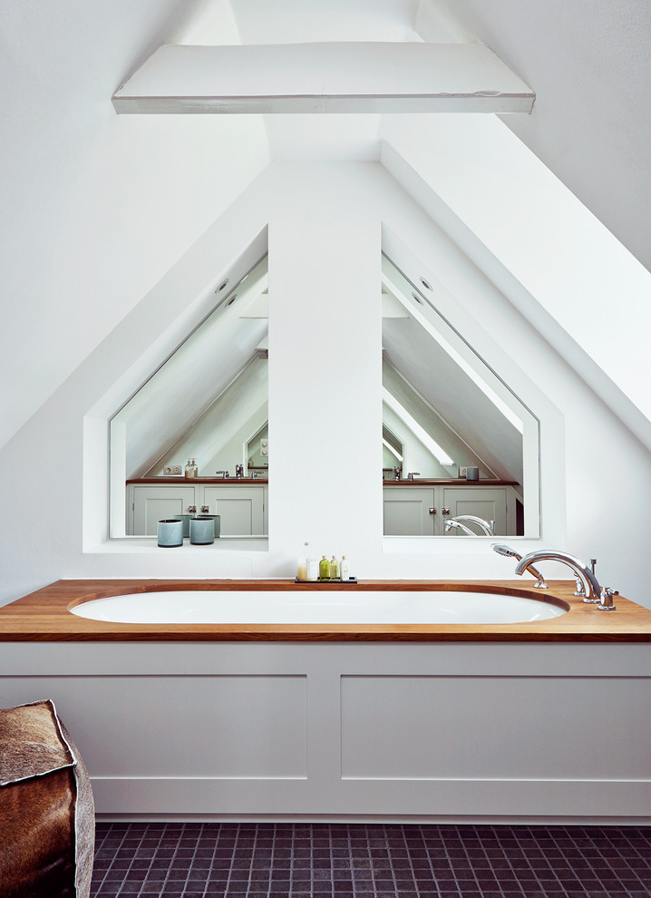 Стильный дизайн: ванная комната среднего размера в стиле кантри с полновстраиваемой ванной, белыми стенами, фасадами в стиле шейкер, белыми фасадами, полом из керамической плитки и столешницей из дерева - последний тренд