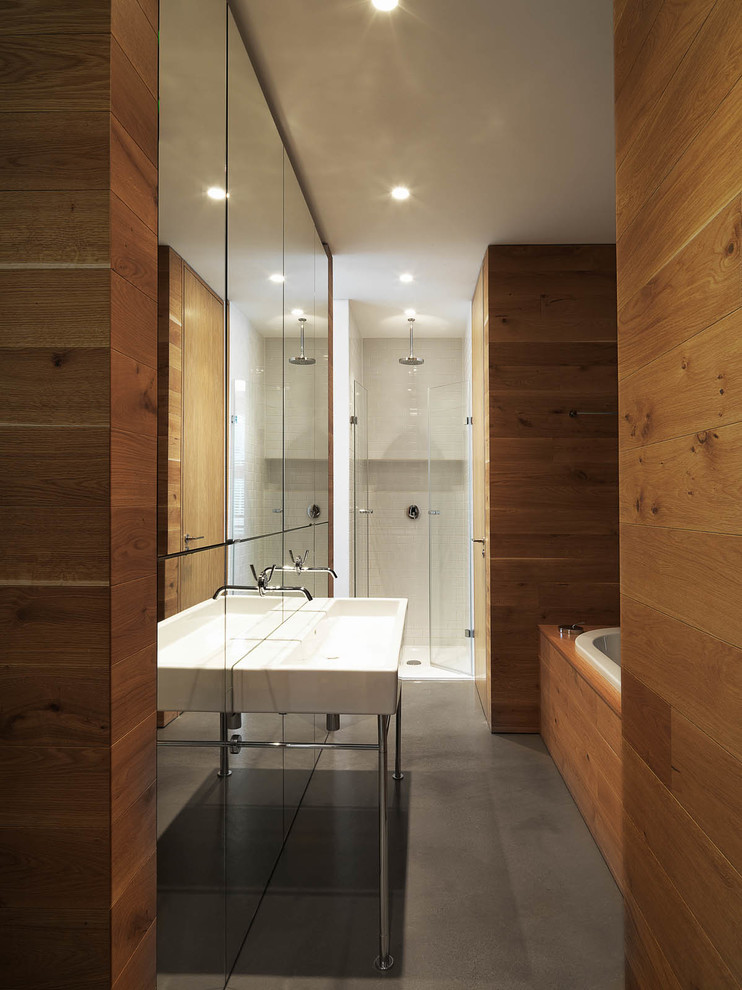 Medium sized contemporary ensuite bathroom in Berlin with a trough sink, a built-in bath, a built-in shower, mirror tiles and concrete flooring.