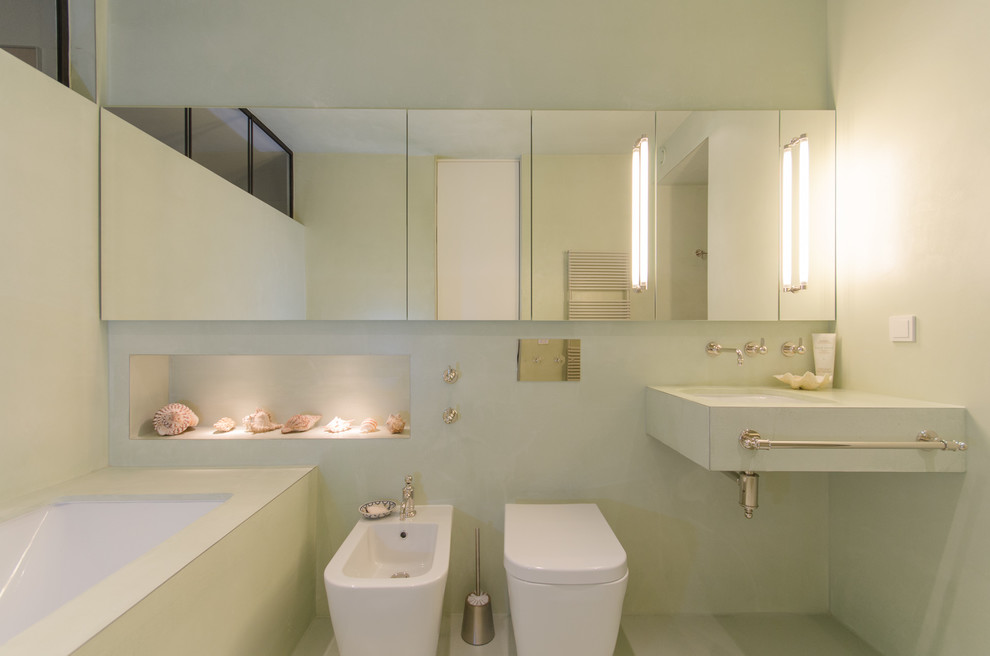 Идея дизайна: ванная комната среднего размера в современном стиле с полновстраиваемой ванной, биде, зелеными стенами, фасадами с выступающей филенкой, зелеными фасадами, душем без бортиков, зеленым полом, открытым душем, монолитной раковиной, нишей и тумбой под одну раковину