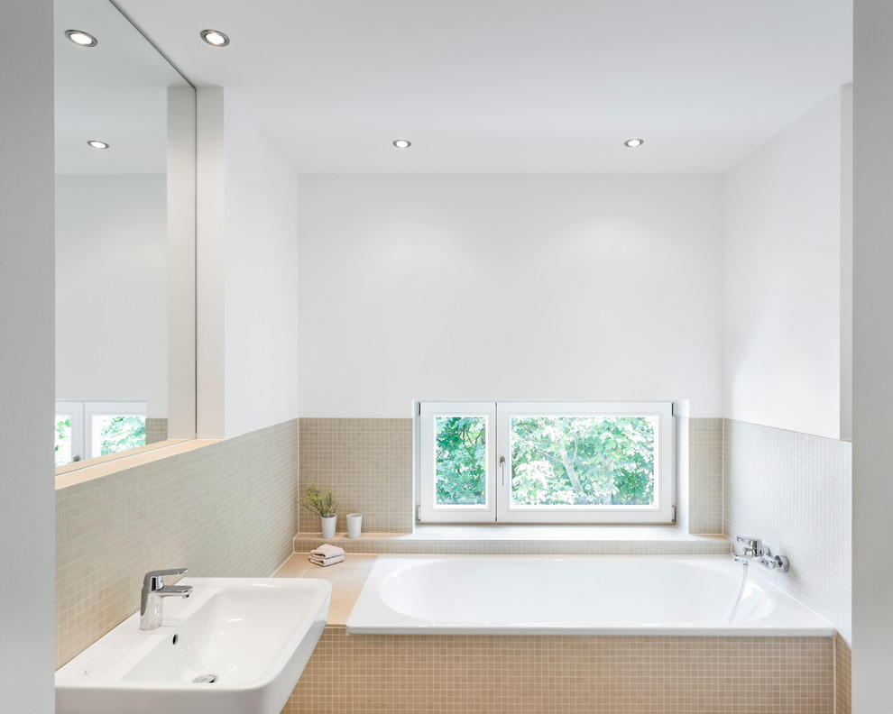 Kleines Modernes Badezimmer mit Wandwaschbecken, Badewanne in Nische, beigen Fliesen, Mosaikfliesen und weißer Wandfarbe in Sonstige