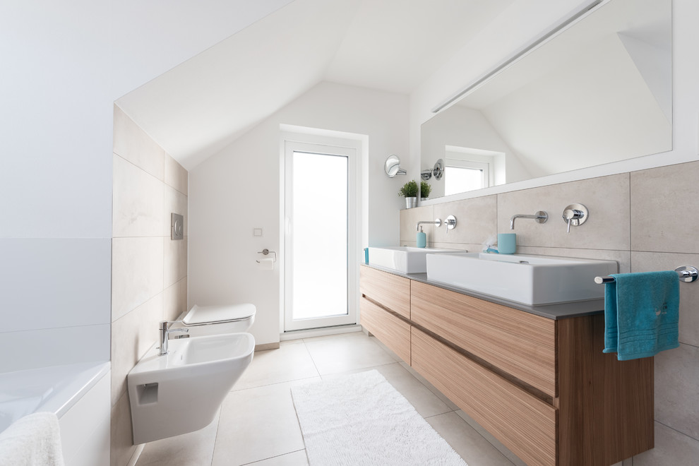 Inredning av ett minimalistiskt mellanstort badrum med dusch, med släta luckor, skåp i mellenmörkt trä, ett platsbyggt badkar, en dusch/badkar-kombination, en bidé, beige kakel, cementkakel, vita väggar, cementgolv, ett fristående handfat och beiget golv