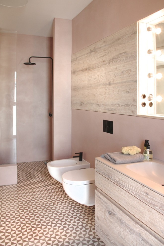 Стильный дизайн: большая ванная комната в современном стиле с плоскими фасадами, светлыми деревянными фасадами, открытым душем, биде, розовыми стенами, душевой кабиной, монолитной раковиной, открытым душем и зеркалом с подсветкой - последний тренд