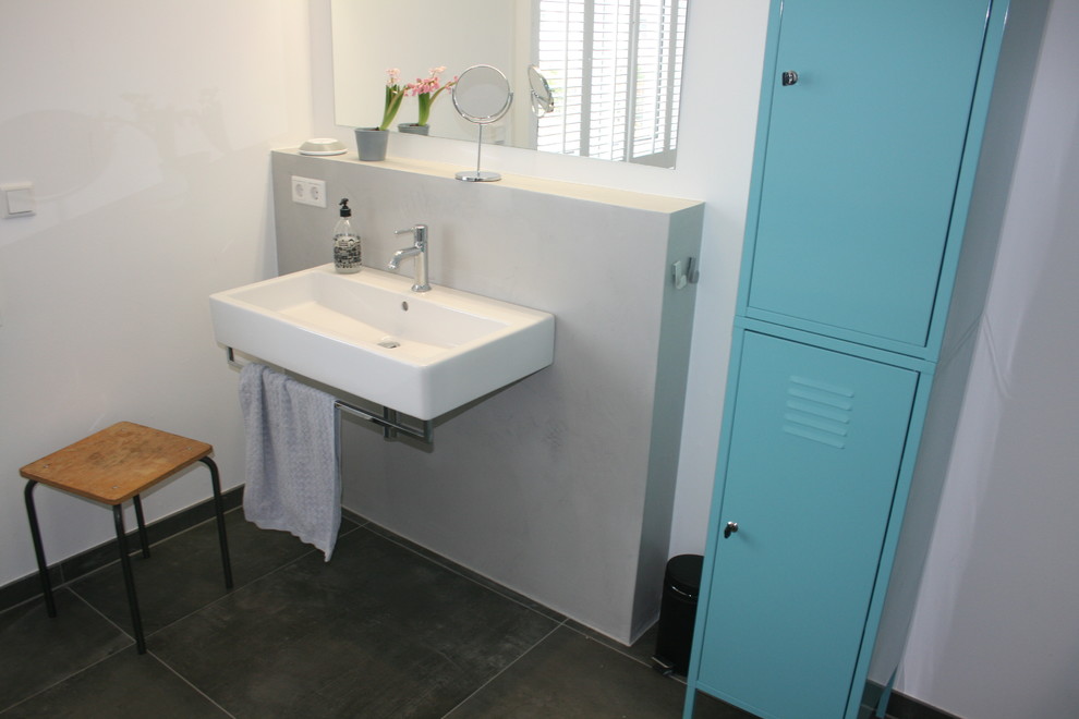 Modernes Badezimmer mit blauen Schränken und weißer Wandfarbe in Köln