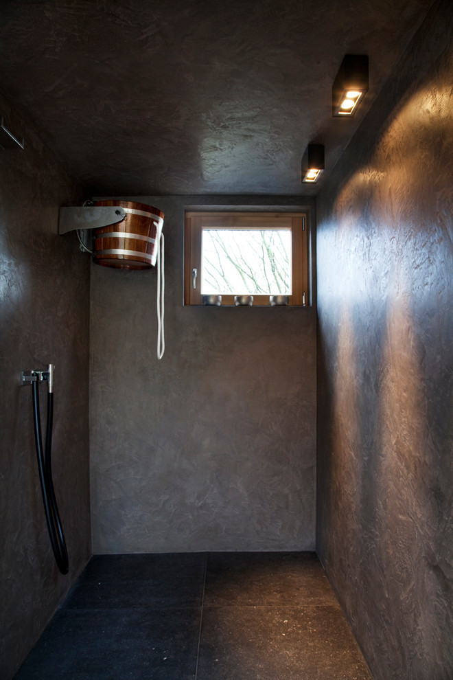 Cette image montre une salle d'eau design de taille moyenne avec un mur marron, un placard à porte plane, une baignoire indépendante, une douche ouverte, WC suspendus, un carrelage gris, du carrelage en marbre, carreaux de ciment au sol, un plan vasque, un sol gris et aucune cabine.