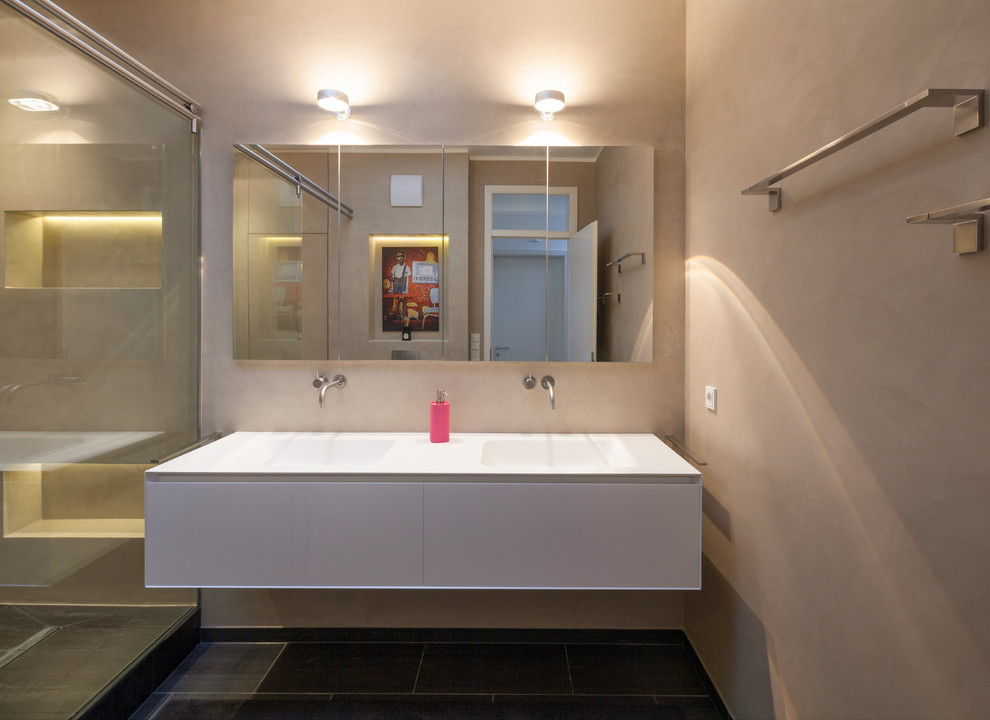 Modernes Badezimmer mit weißen Schränken, bodengleicher Dusche und beiger Wandfarbe in Köln