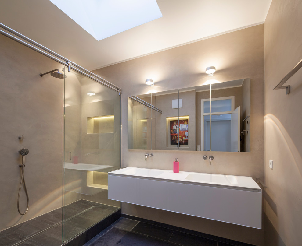 Modernes Badezimmer mit weißen Schränken, bodengleicher Dusche, beiger Wandfarbe und Trogwaschbecken in Köln