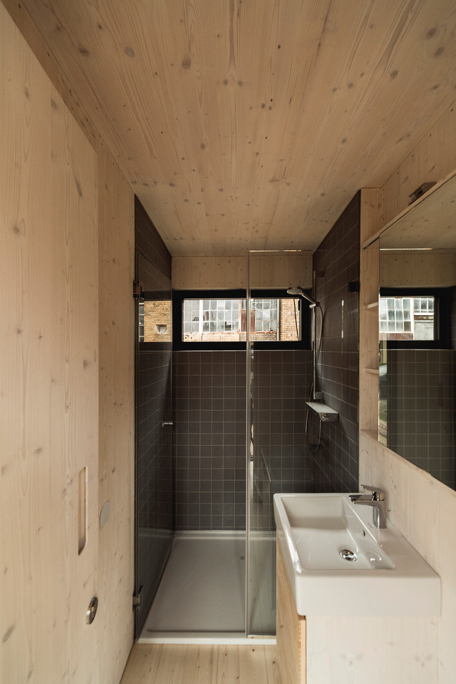 Small contemporary shower room bathroom in Berlin with light wood cabinets, grey tiles, ceramic tiles, light hardwood flooring and beaded cabinets.
