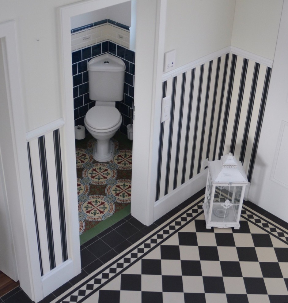 Inspiration pour une petite salle de bain rustique avec WC à poser, un carrelage bleu, des carreaux de céramique, un mur blanc, carreaux de ciment au sol, un plan vasque et un sol vert.