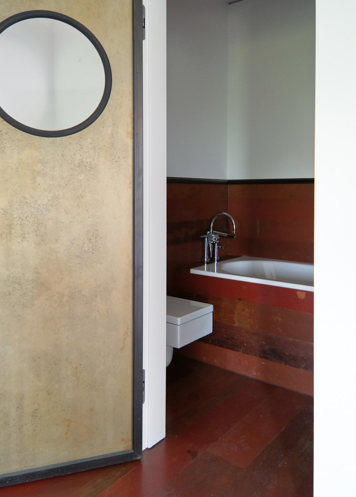 Bild på ett mellanstort industriellt badrum, med ett platsbyggt badkar, träbänkskiva, vita väggar, mellanmörkt trägolv och ett nedsänkt handfat