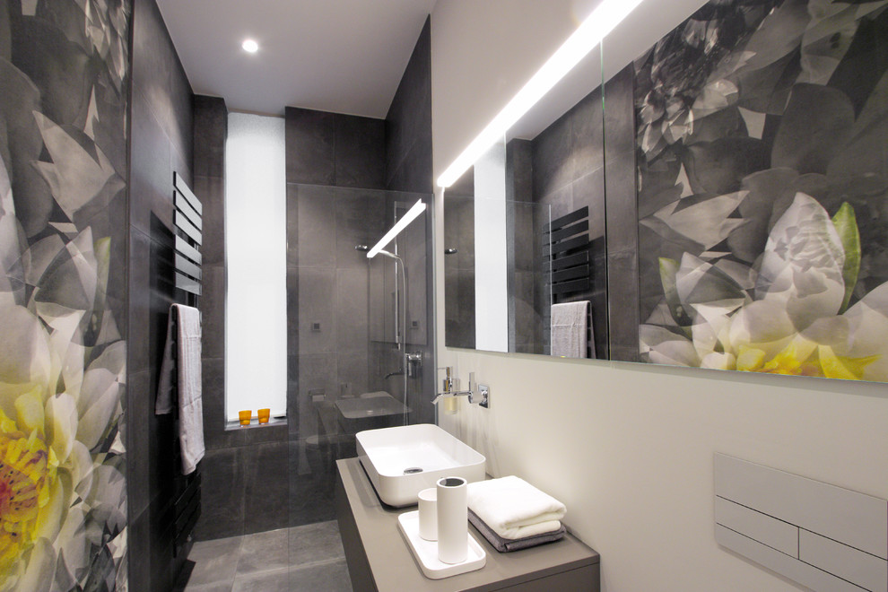 Idéer för att renovera ett litet funkis grå grått badrum med dusch, med släta luckor, grå skåp, en öppen dusch, en vägghängd toalettstol, grå kakel, vita väggar, ett fristående handfat, grått golv och med dusch som är öppen
