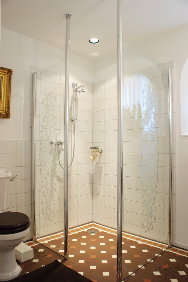 Foto på ett vintage badrum med dusch, med vita skåp, ett fristående badkar, en kantlös dusch, vit kakel, vita väggar, cementgolv, brunt golv och dusch med skjutdörr