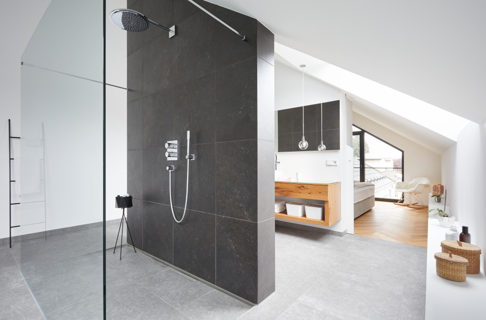 На фото: главная ванная комната в современном стиле с открытыми фасадами, светлыми деревянными фасадами, душем без бортиков, черной плиткой, белыми стенами, серым полом, открытым душем, подвесной тумбой и сводчатым потолком