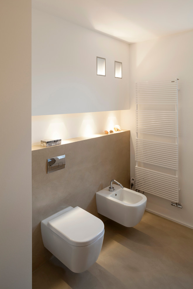 Modern inredning av ett mellanstort vit vitt badrum med dusch, med släta luckor, vita skåp, en bidé, betonggolv, bänkskiva i akrylsten och beiget golv
