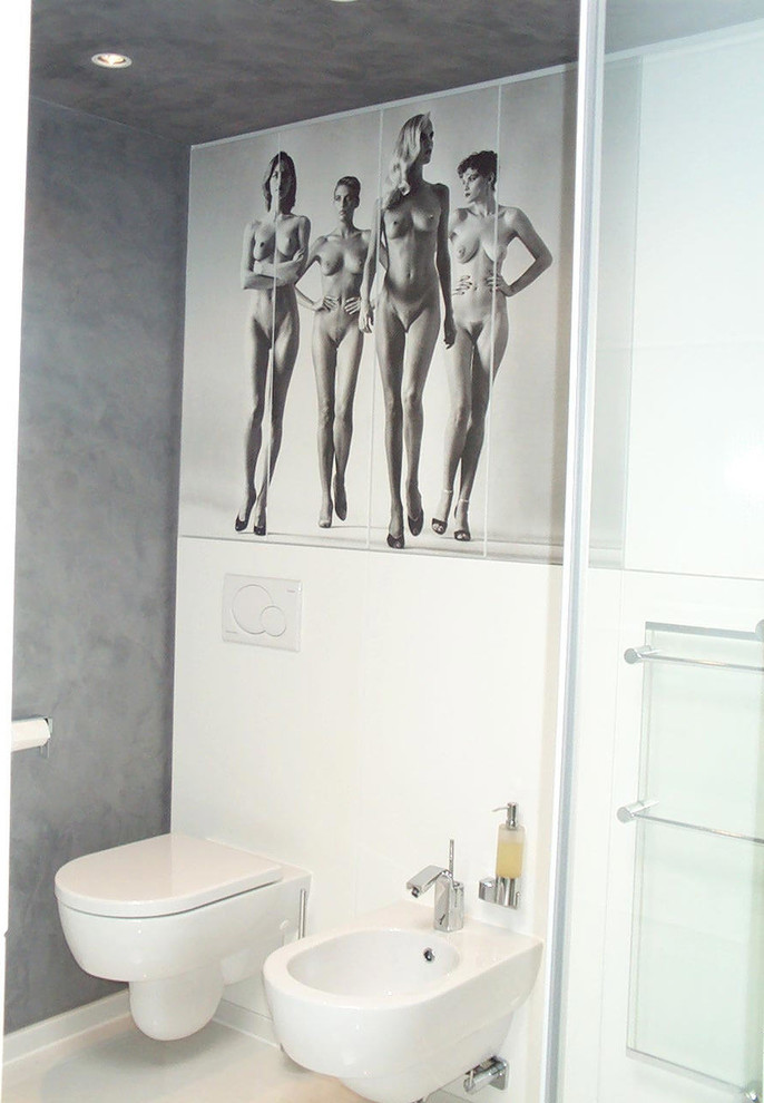 Modern inredning av ett svart svart badrum med dusch, med släta luckor, vita skåp, en kantlös dusch, en vägghängd toalettstol, vit kakel, glasskiva, grå väggar, ett fristående handfat, granitbänkskiva, vitt golv och marmorgolv