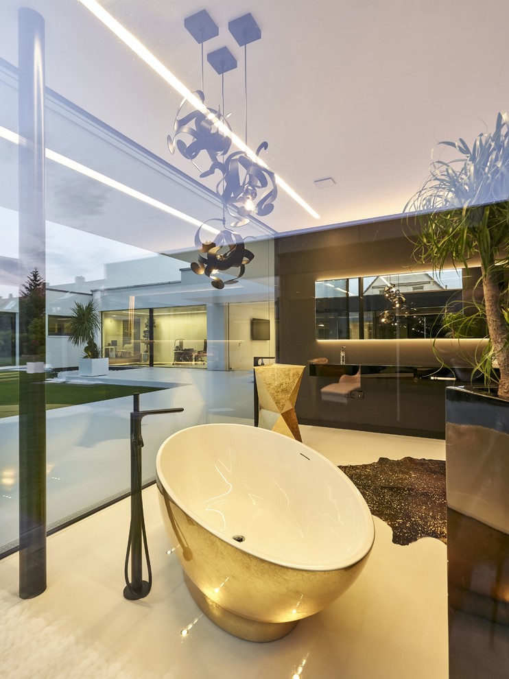 Immagine di una stanza da bagno moderna con vasca freestanding, pareti grigie, lavabo a colonna e pavimento bianco